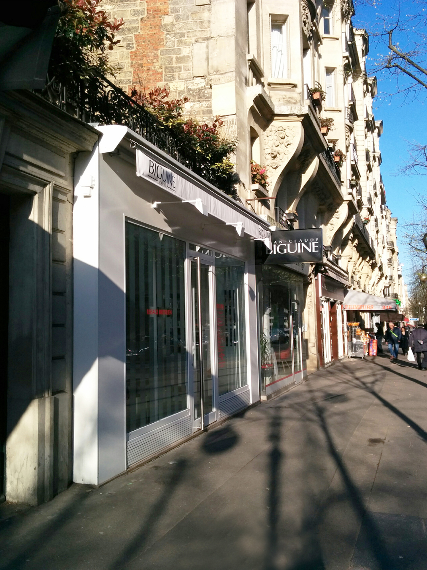 Photo de la devanture de l'entrée depuis le trottoir d'un salon de coiffure parisien