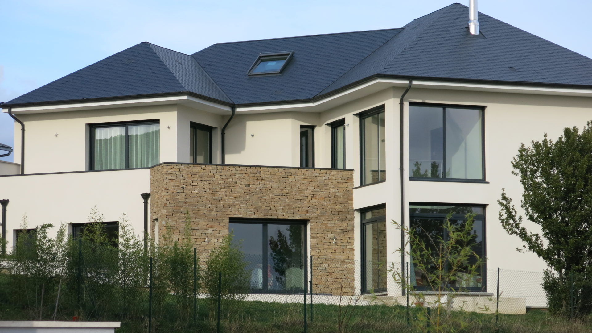 Photo d'une grande maison construite avec de volumes simples et une toiture en pente