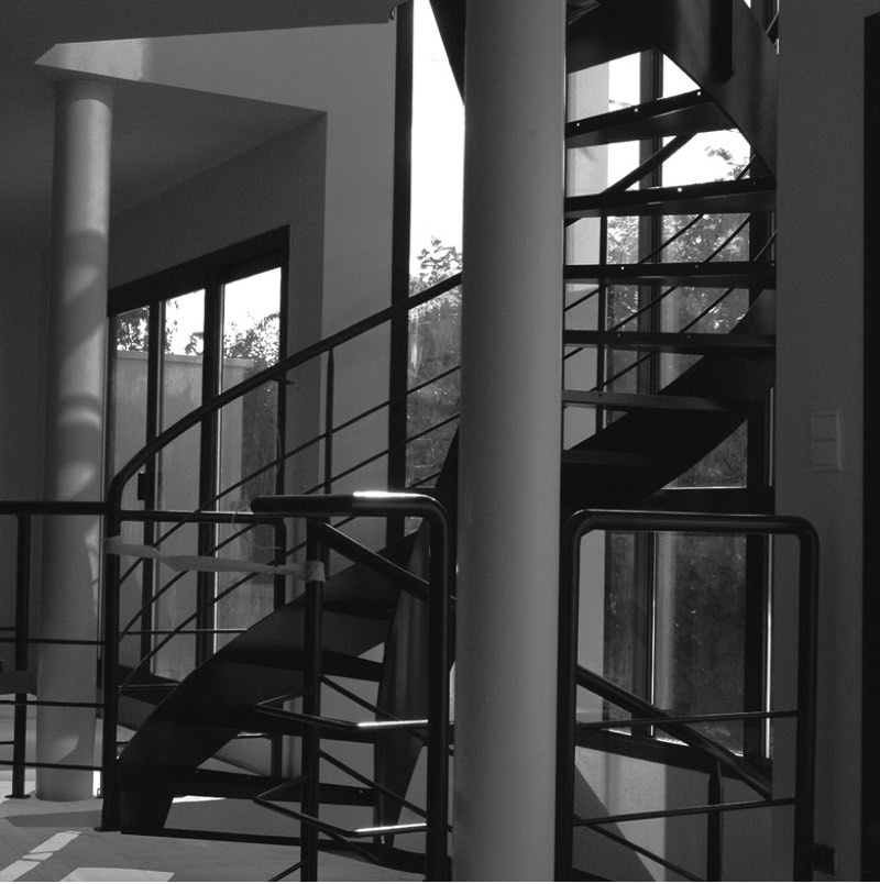 Interior black and white photo of a metal staircase